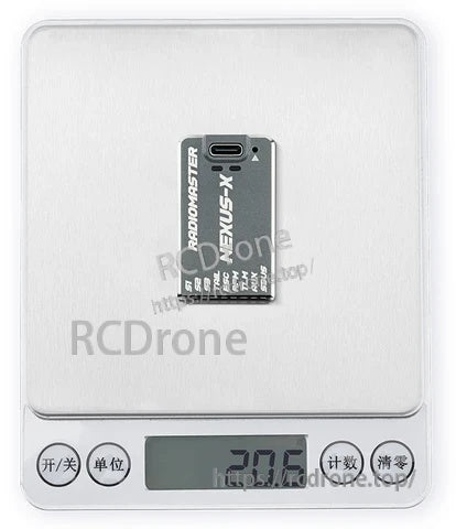 NEXUS-X helicopter flight controller on digital scale reading 20.6 g for installed weight reference