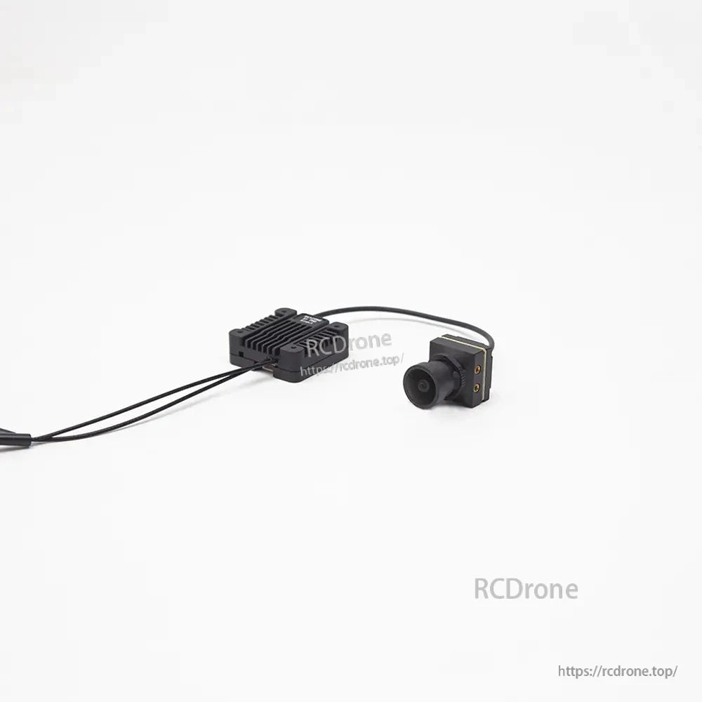 FPV camera and SKYZONE air unit linked by cable, camera front lens view with transmitter in background