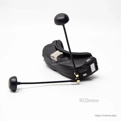 Receiver installed on FPV goggles with two antennas attached, showing side-mounted module fitment