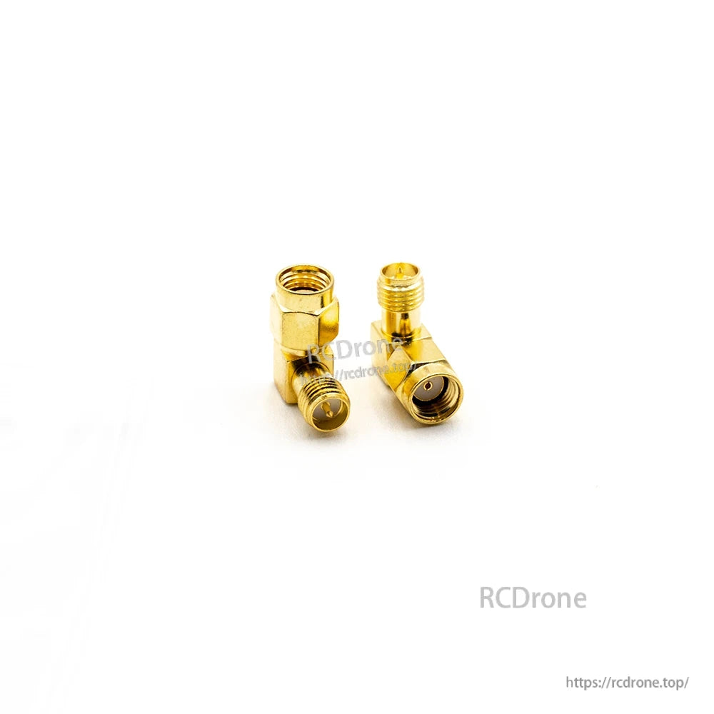 Right-angle gold coax adapter pair, close-up showing one male-threaded end and one female end