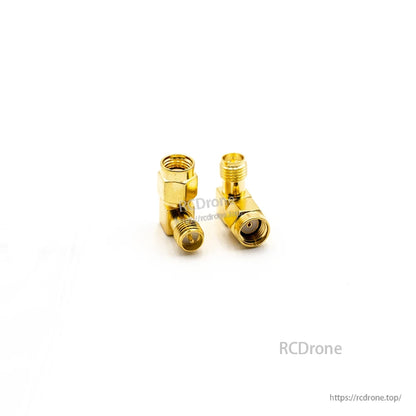 Right-angle gold coax adapter pair, close-up showing one male-threaded end and one female end