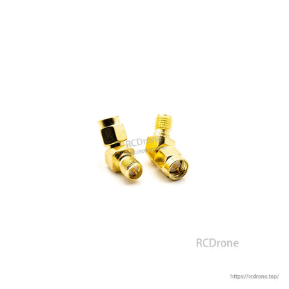 Gold elbow coax adapters, 90-degree connectors shown from diagonal angle with hex bodies
