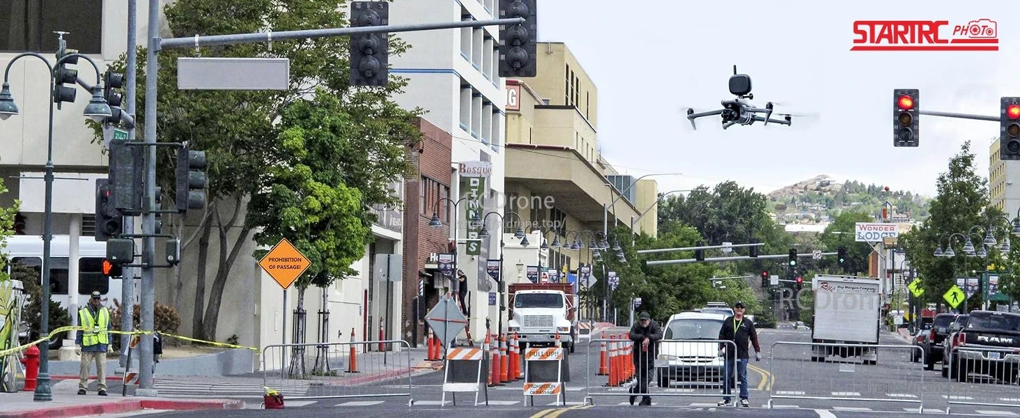 STARTRC Drone Speaker, A STARTRC drone with red lights hovers above a busy urban street, surrounded by traffic, construction barriers, and workers.