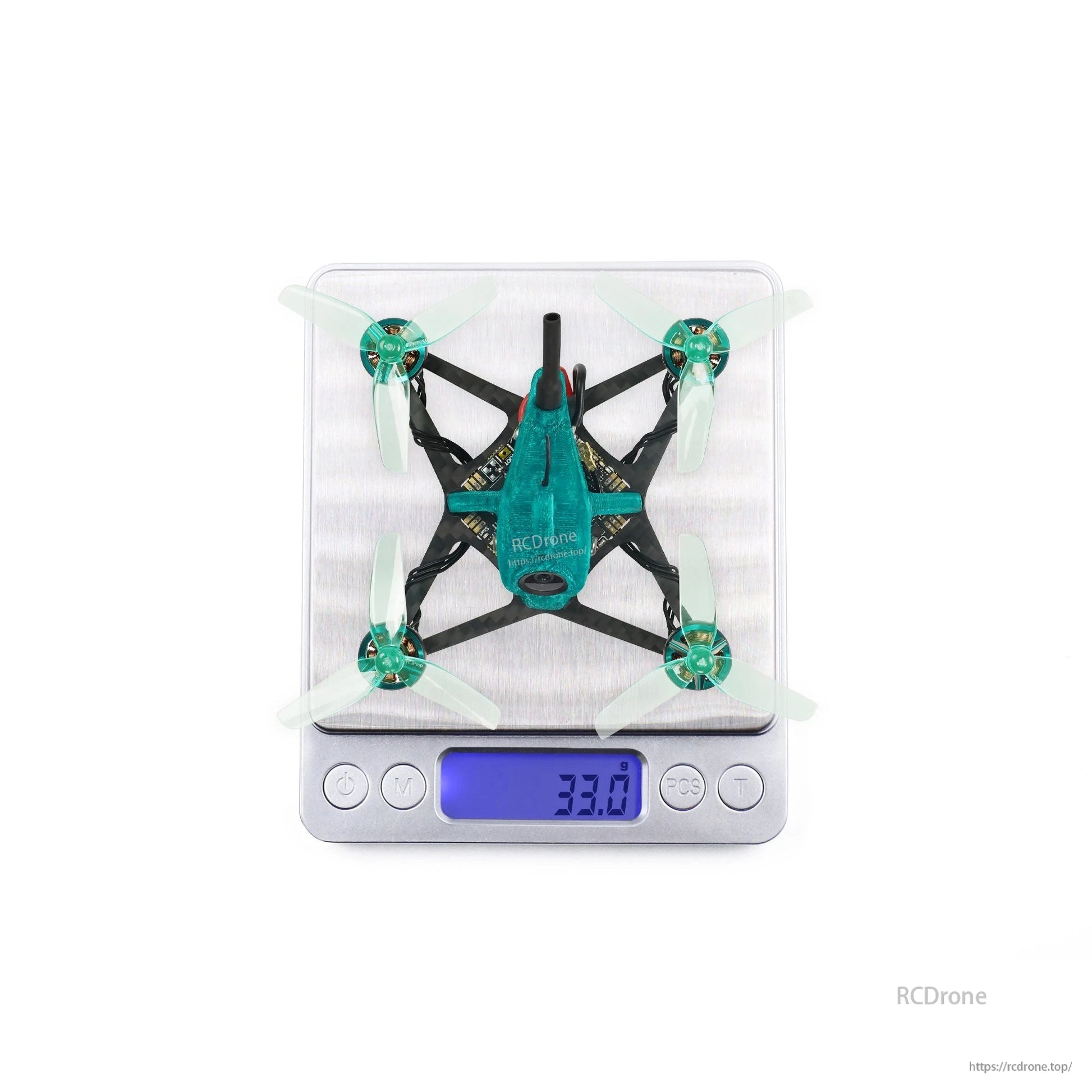Top view of quadcopter on digital scale displaying 33.0 g weight reading
