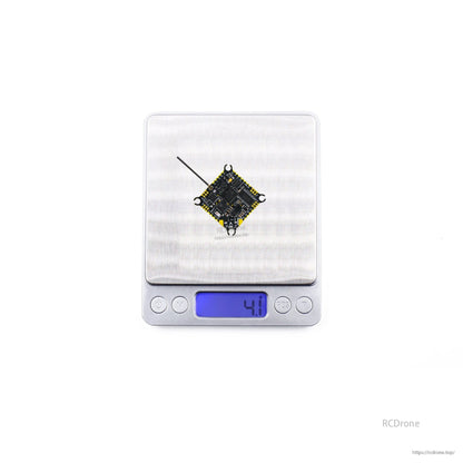 Flight controller on digital scale showing 4.1 g weight reading with antenna attached