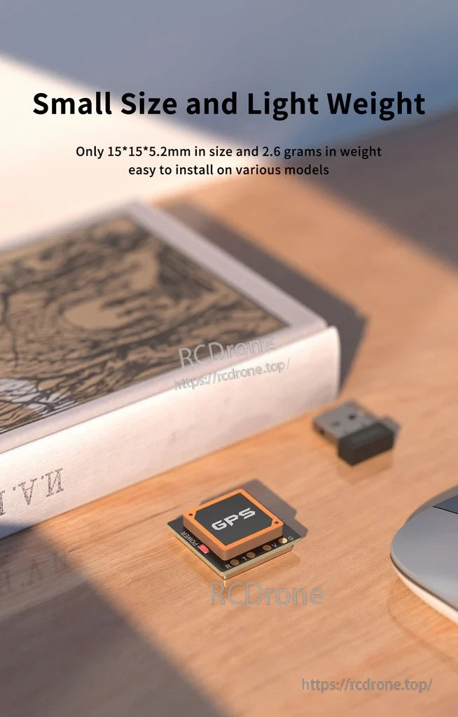 Small and lightweight GPS module on a desk, emphasizing 15×15×5.2 mm footprint and 2.6 g weight