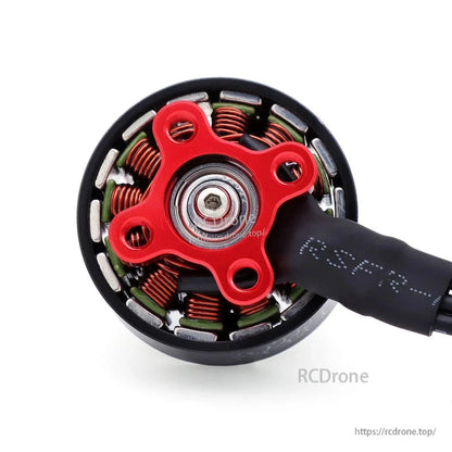 Underside close-up of the motor showing the red mounting base, windings, and bearing