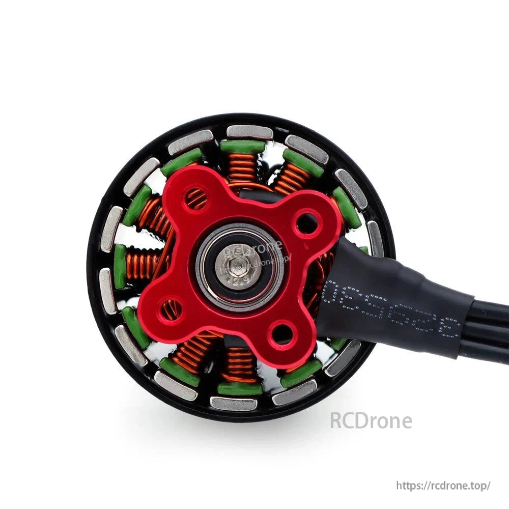 Underside view of FPV brushless motor showing red mounting base, bearing, stator, and wire lead