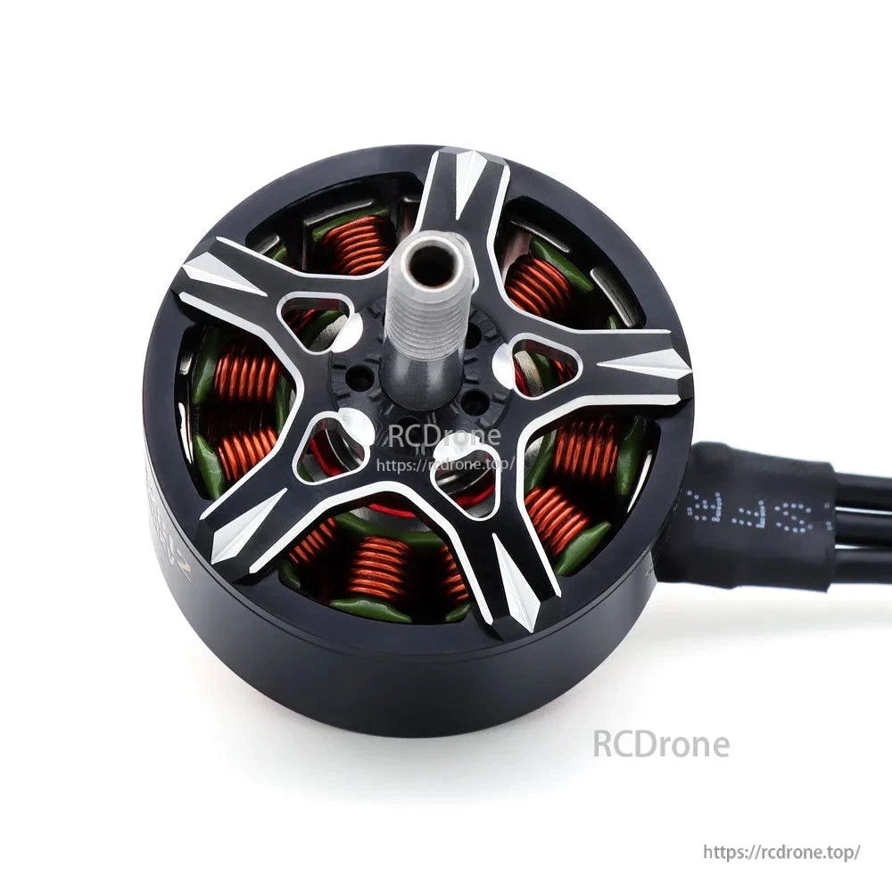 Top view of brushless motor rotor showing silver cutouts, copper windings, and threaded shaft