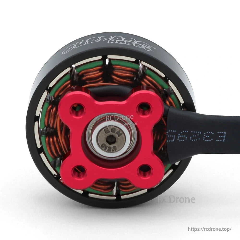 Underside view of red four-hole mounting base, bearing, copper windings, and motor cable