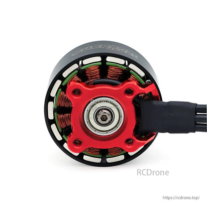 Bottom view of red motor base and central bearing, copper windings visible around the stator