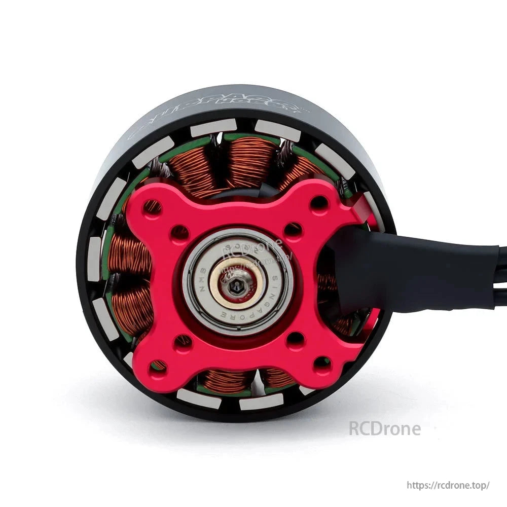 Underside close-up of the brushless motor showing red mounting plate, bearing, windings, and cable exit
