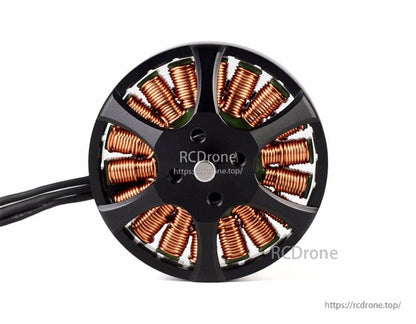 Top view of a T-Motor brushless outrunner drone motor with exposed copper windings and three phase leads