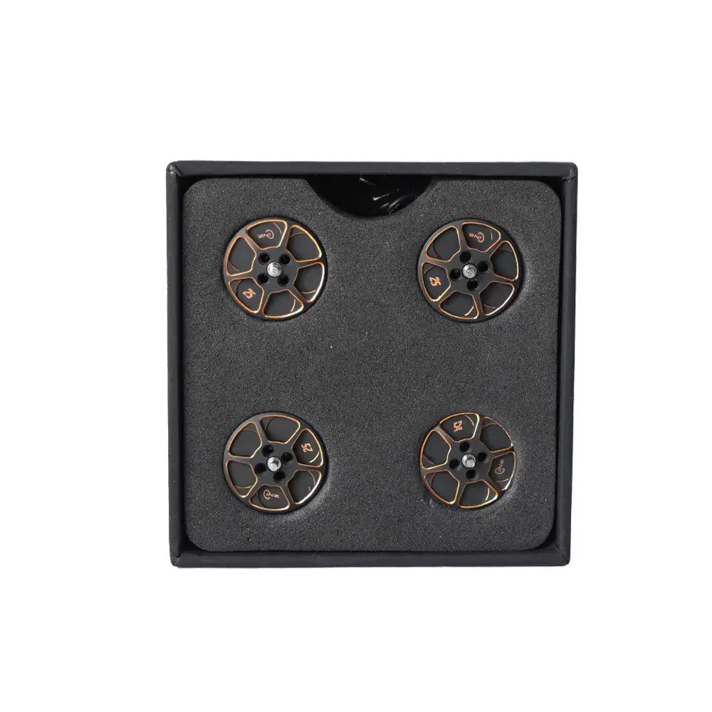 Set of four black and gold anodized T-Motor drone motor parts arranged in a foam-lined box