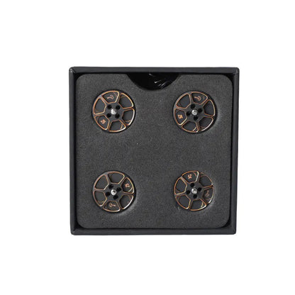 Set of four black and gold anodized T-Motor drone motor parts arranged in a foam-lined box