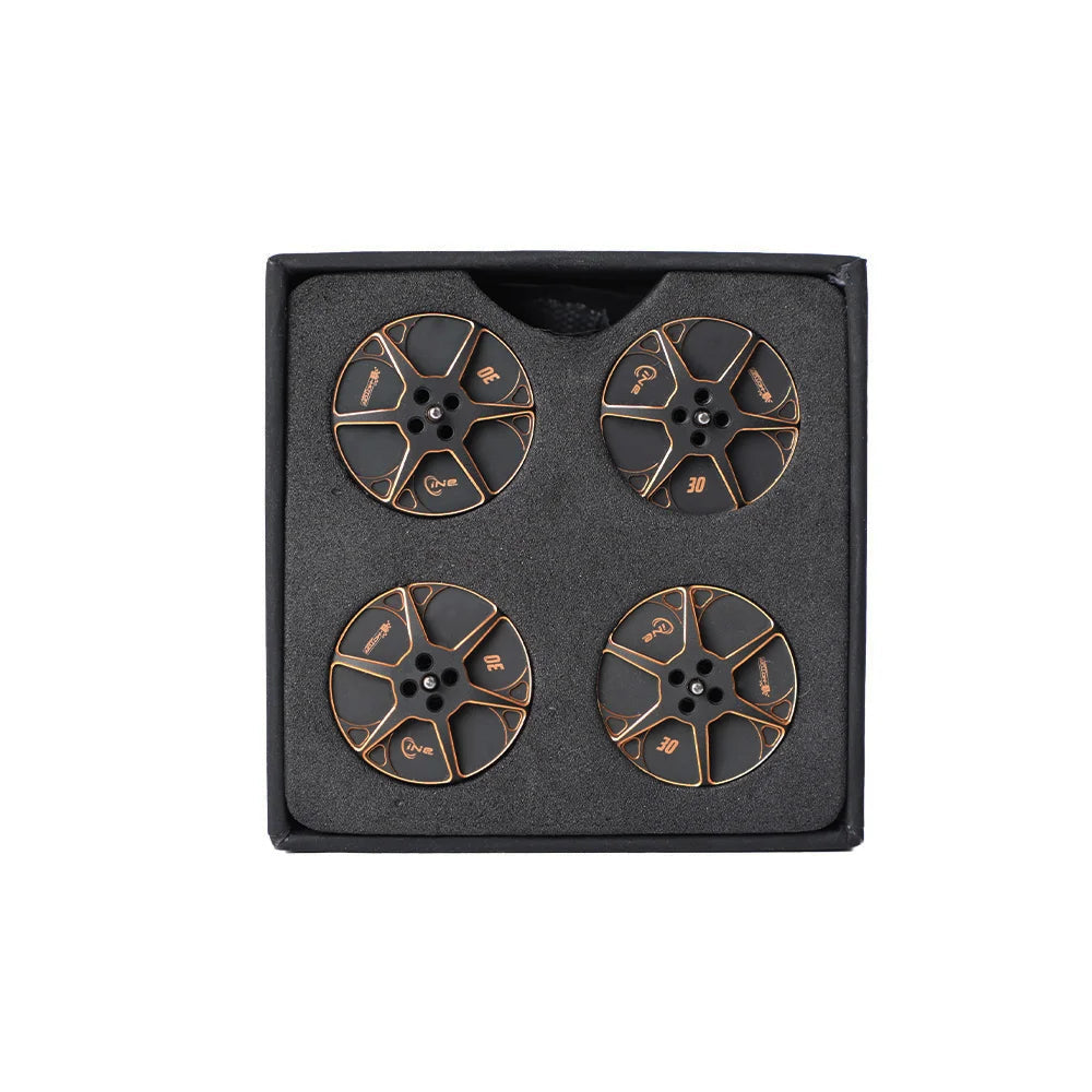 Set of four black and gold T-Motor round metal components with center mounting holes in foam packaging