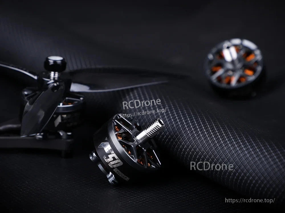 T-Motor style brushless drone motor with threaded shaft and exposed copper windings on a black carbon surface