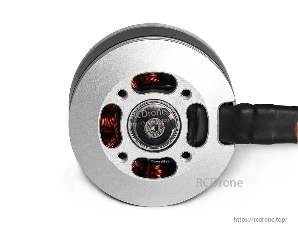 Bottom view of a T-Motor brushless drone motor showing copper windings, mounting holes, and wired lead