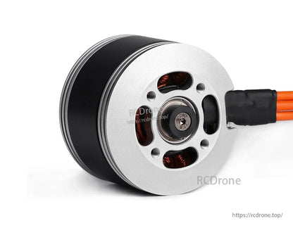 Close-up of a T-Motor brushless outrunner motor with silver endplate, mounting holes, and orange wires