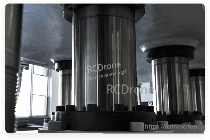 Close-up of industrial machine columns with metal housings and bolt-mounted bases in a factory setting