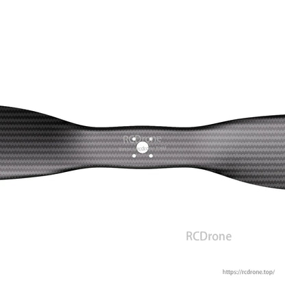 Close-up of a matte carbon fiber VTOL propeller blade with woven finish and flange-mount bolt holes
