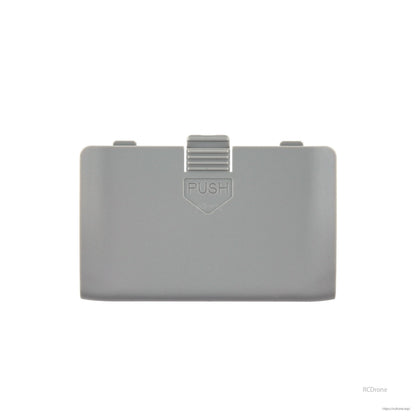 TX15 radio battery cover in gray with 'PUSH' latch tab, straight-on front view