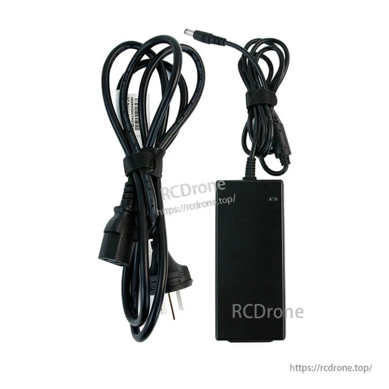 AC adapter power supply with US 2‑prong power cable and attached DC barrel connector lead, flat lay