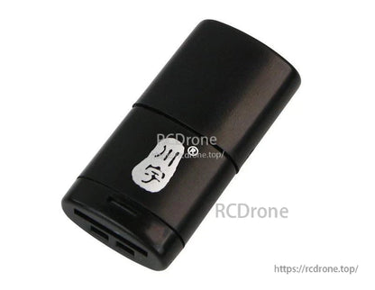 Angled view of compact black card reader, slot end visible with protective cap on
