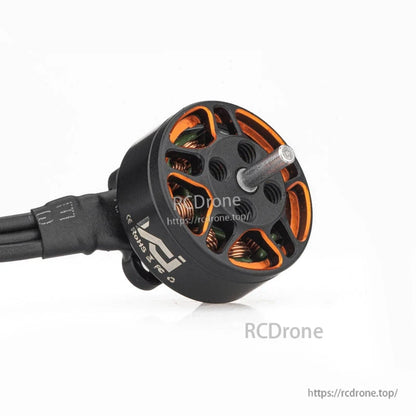 Angled view of brushless motor with output shaft and open bell revealing copper windings