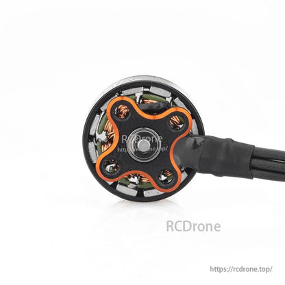 Bottom view of 1104 brushless motor base with four mounting holes, copper windings, and wire bundle