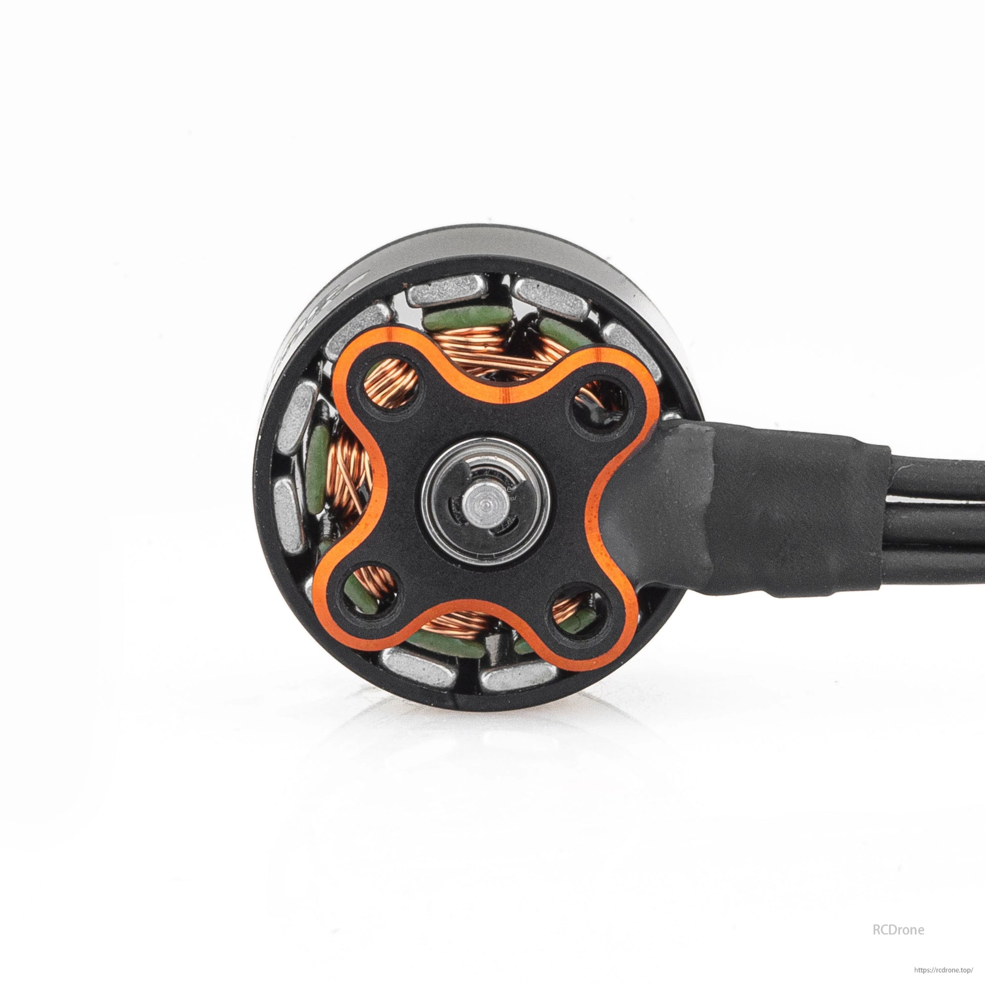 Bottom view of motor base showing four-lobe mounting plate, bearing center, and wire lead