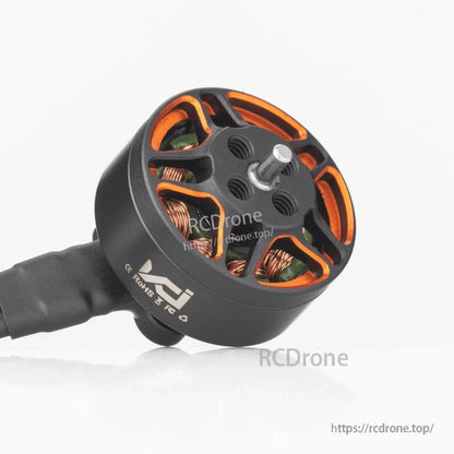 Angled view of brushless motor with orange bell cutouts, attached lead wires, and side marking