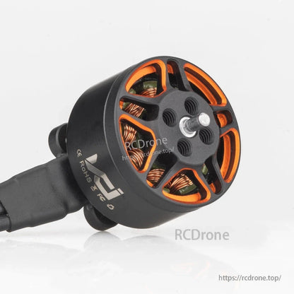 Angled top view of SPARK 1306 motor showing threaded prop mount holes and orange bell cutouts