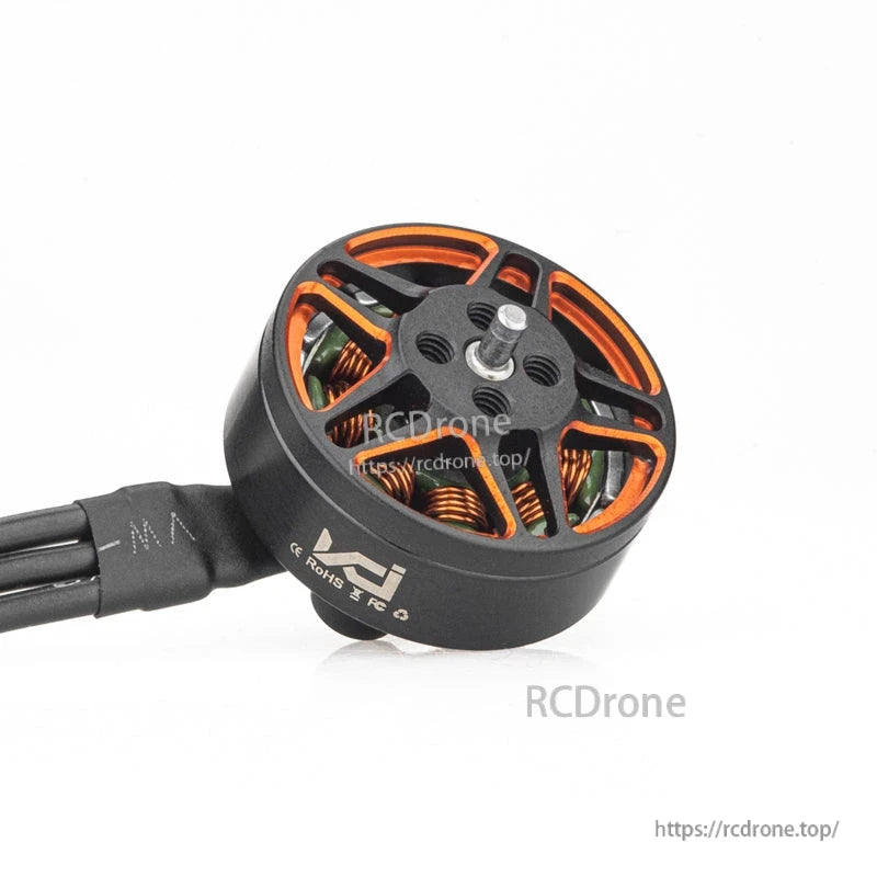 Angled view of motor top showing shaft, mounting holes, and orange internal windings