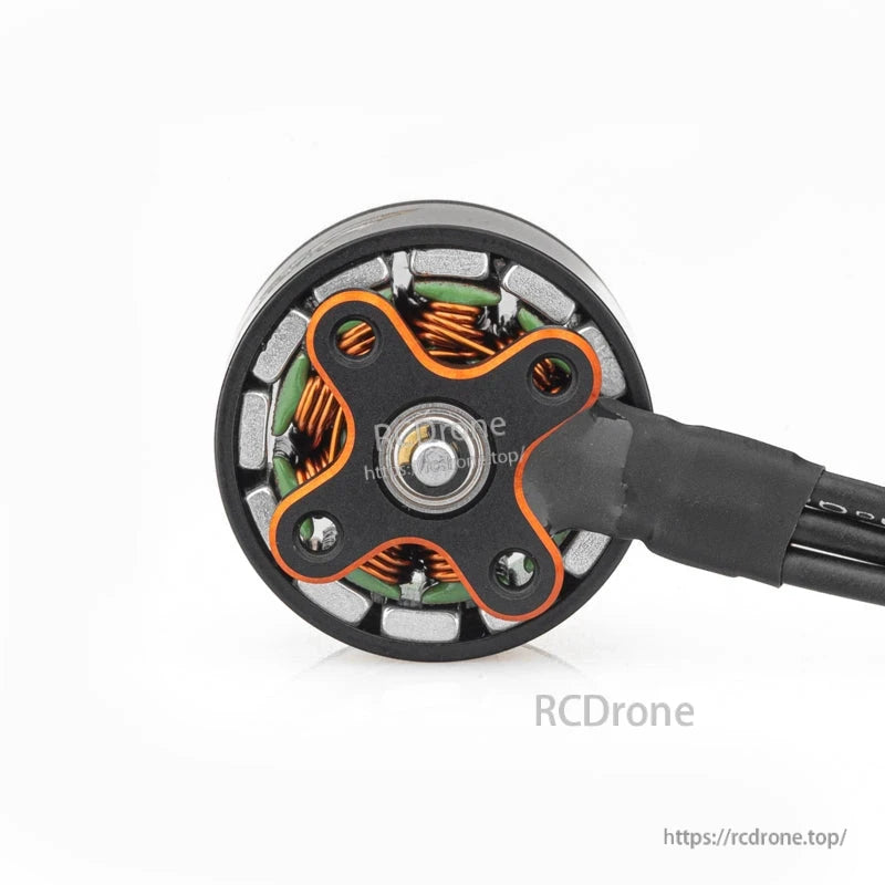 Bottom view of brushless motor showing mounting base, central bearing, and orange X-style plate
