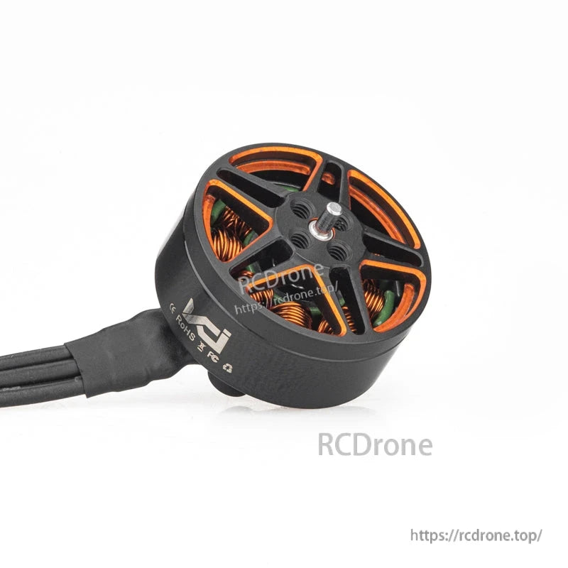 Angled view of motor can with orange cutouts, exposed windings, and attached power leads