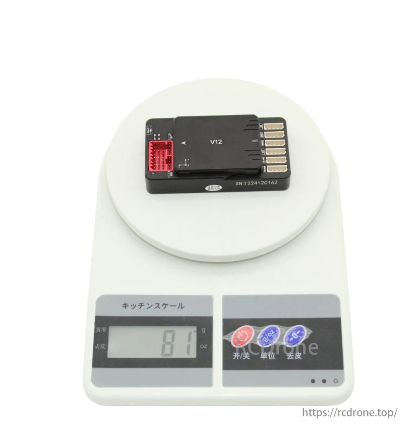 VK V12 autopilot flight controller on kitchen scale, displaying 81 grams.