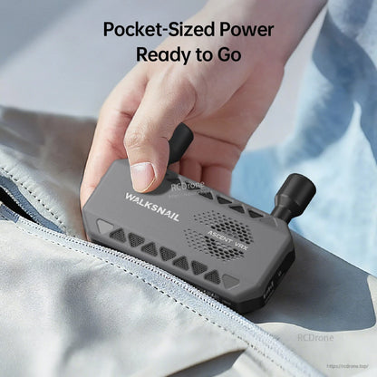 Pocket-size receiver held in hand and placed into a bag, showing compact portable design