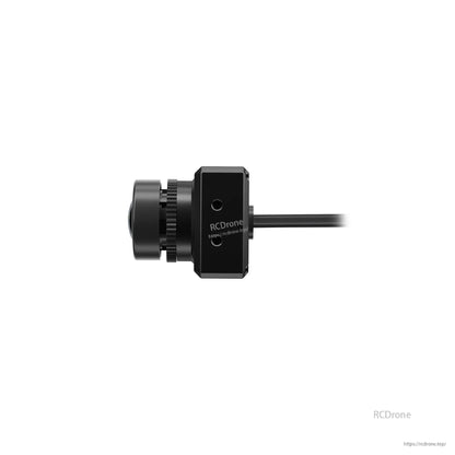 Side profile of FPV camera showing protruding lens assembly, square body, and rear cable