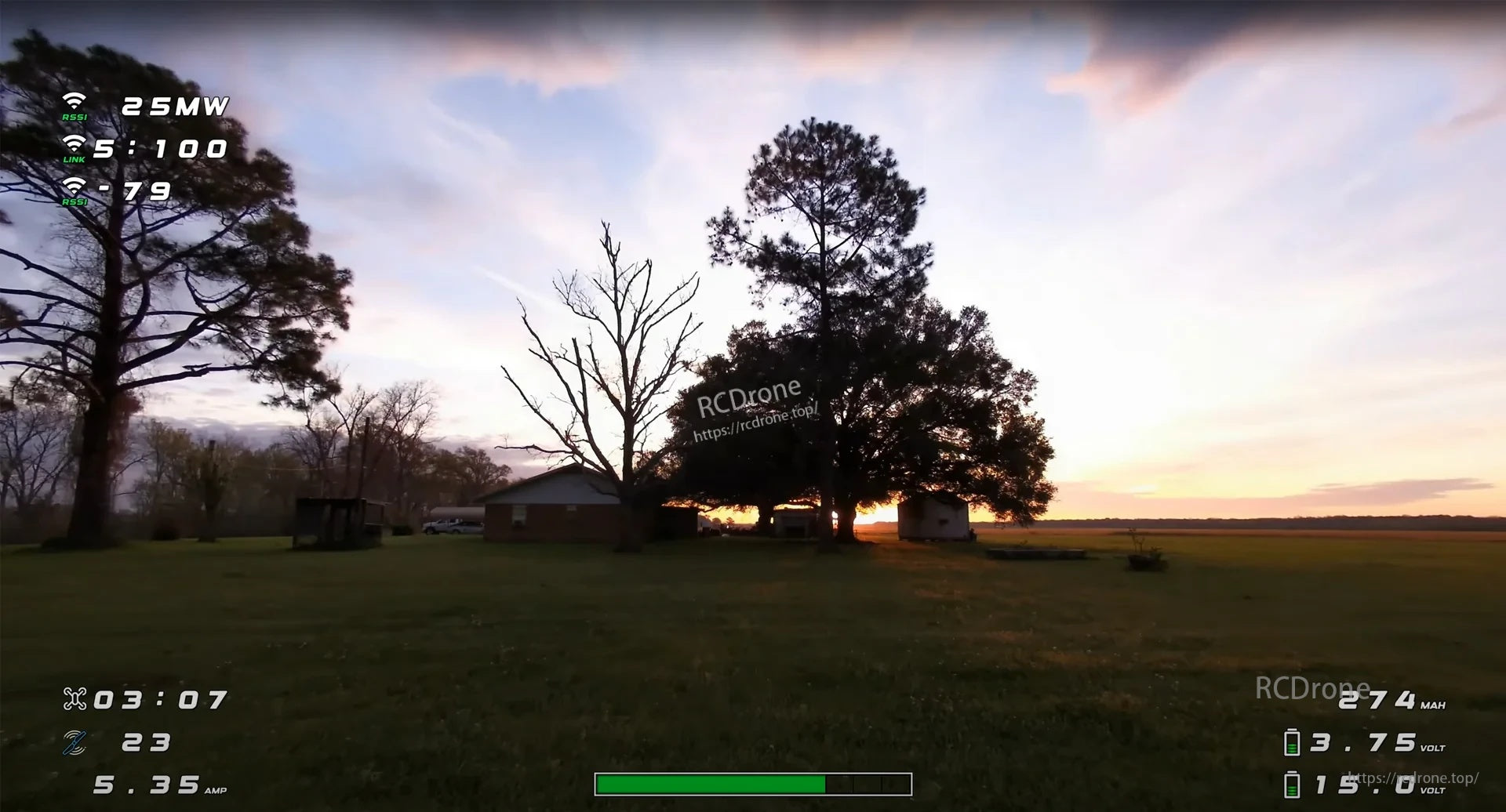 On-screen FPV DVR view flying over a grassy field at sunset with telemetry overlay