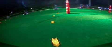 Low-light FPV sample footage over a lit course, demonstrating night visibility performance