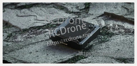 Avatar V2 VTX module resting on rocky surface, emphasizing rugged compact metal housing