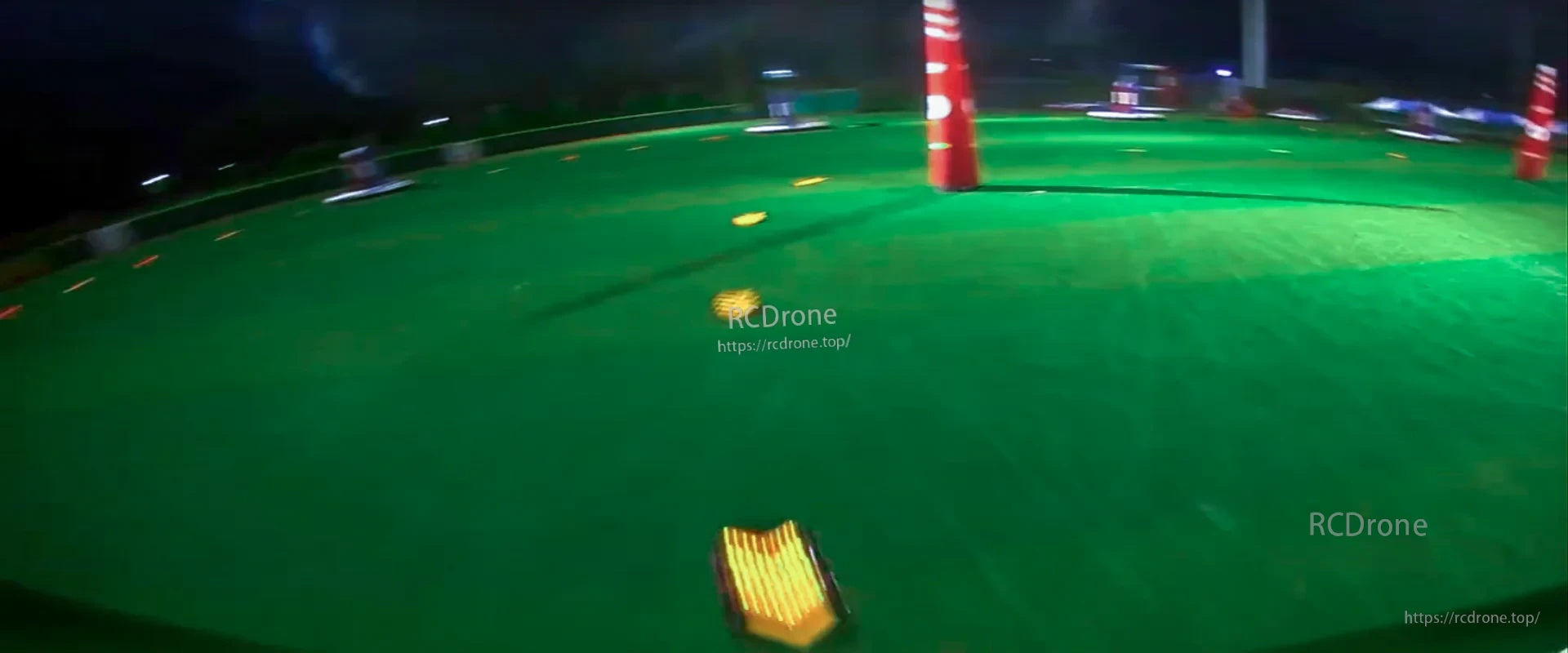 FPV racing flight sample frame with motion blur over a green course at night
