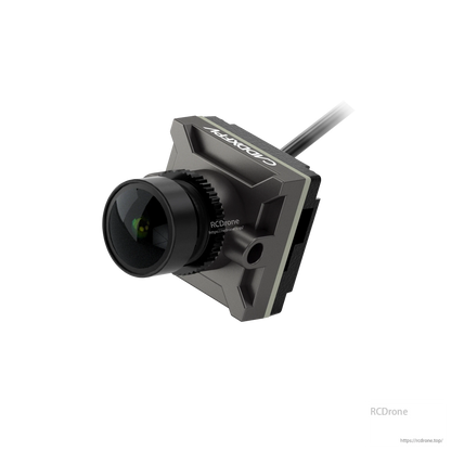 Gray housing FPV camera close-up, angled view highlighting lens barrel, side port, and cable
