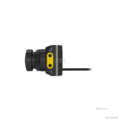 Side profile of FPV camera showing lens barrel, yellow side plate with two screws, and rear cable