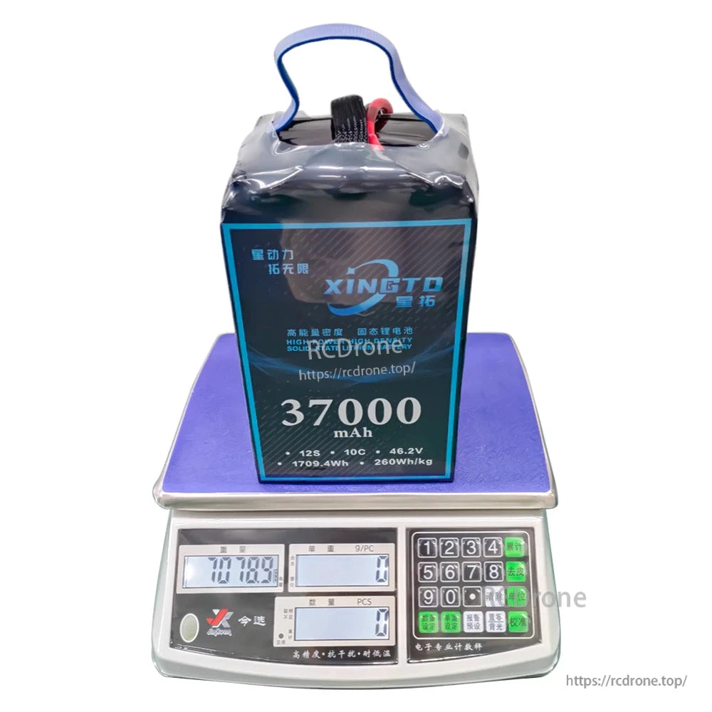 XINGTO 12S solid-state lithium battery: 37,000mAh, 46.2V, 10C, 260Wh/kg. High energy density, ideal for UAV drones. Displayed on a digital scale. (24 words)