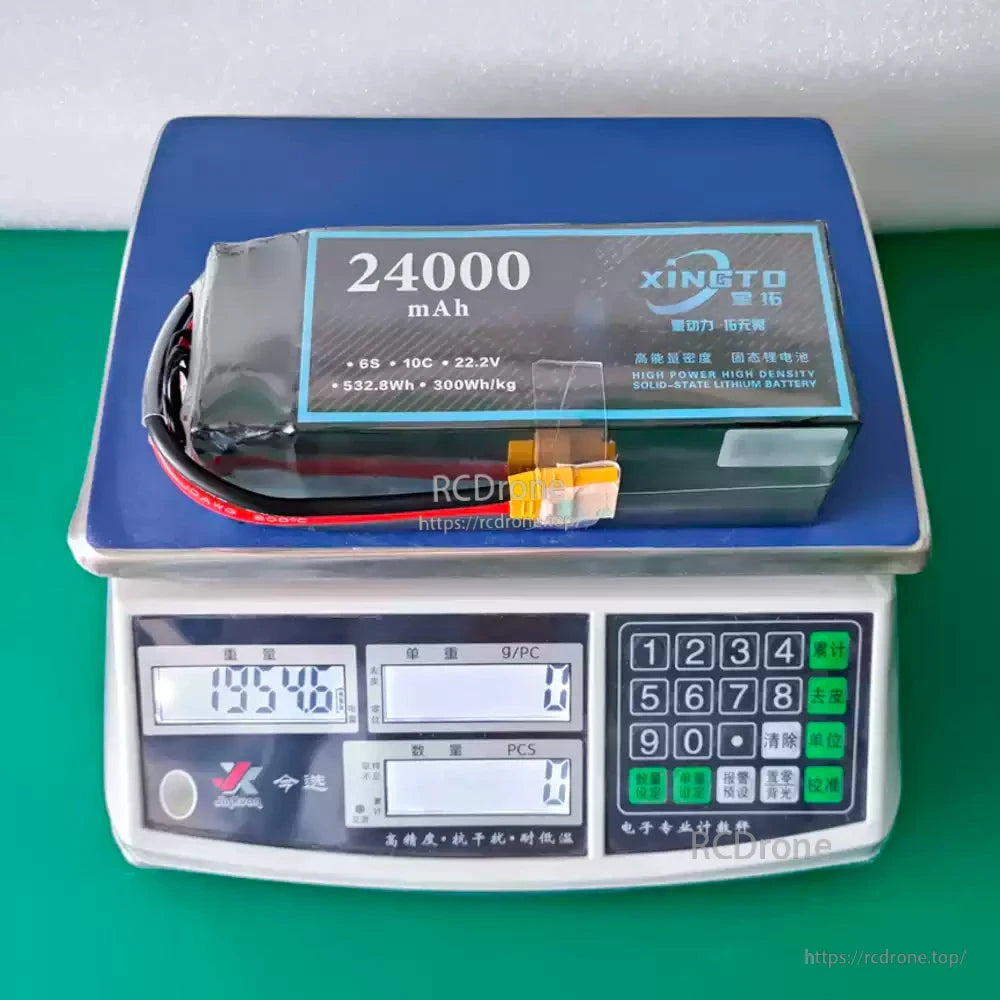 XINGTO 24000mAh 6S 10C 22.2V solid-state lithium battery, 532.8Wh, 300Wh/kg, weighs 1358g, high power and density, shown on digital scale.