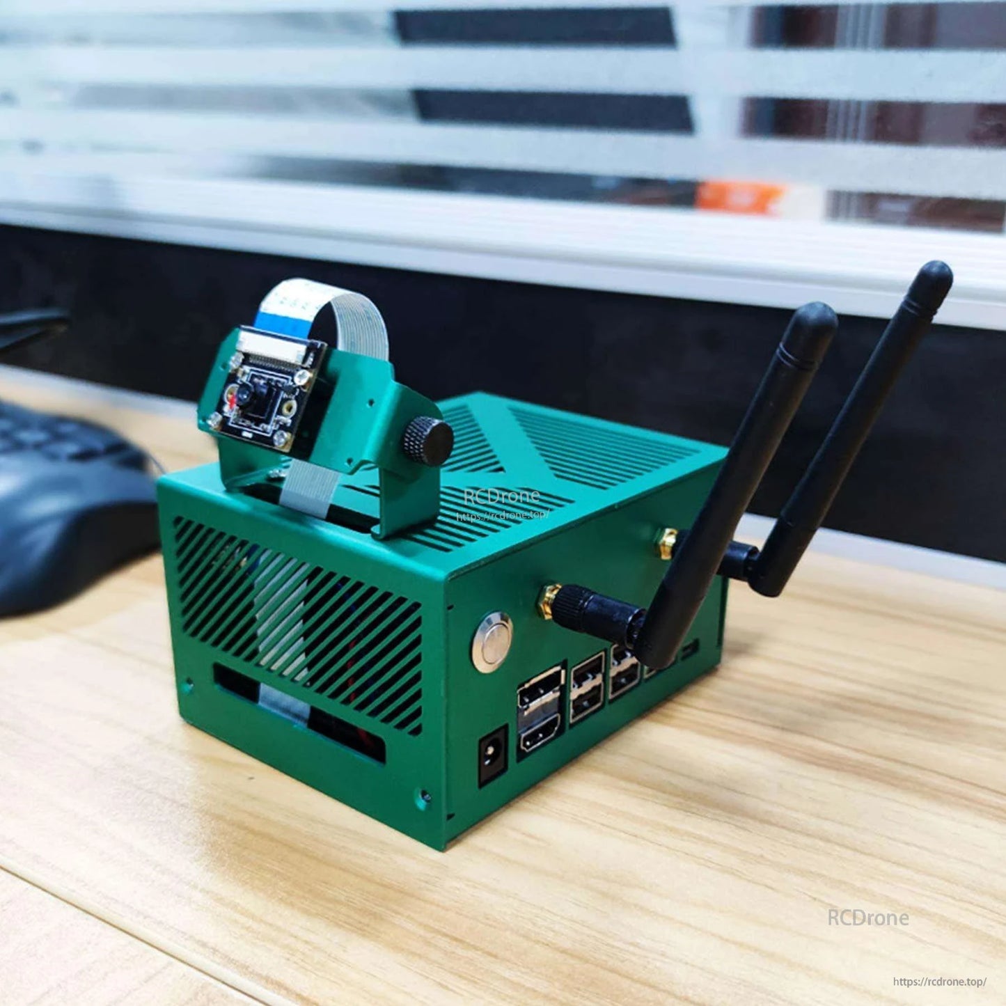 Yahboom Green Aluminum Alloy Case on desk setup with dual antennas and ribbon-mounted camera bracket