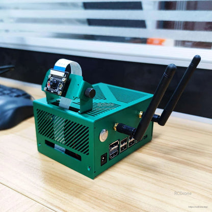 Yahboom Green Aluminum Alloy Case on desk setup with dual antennas and ribbon-mounted camera bracket