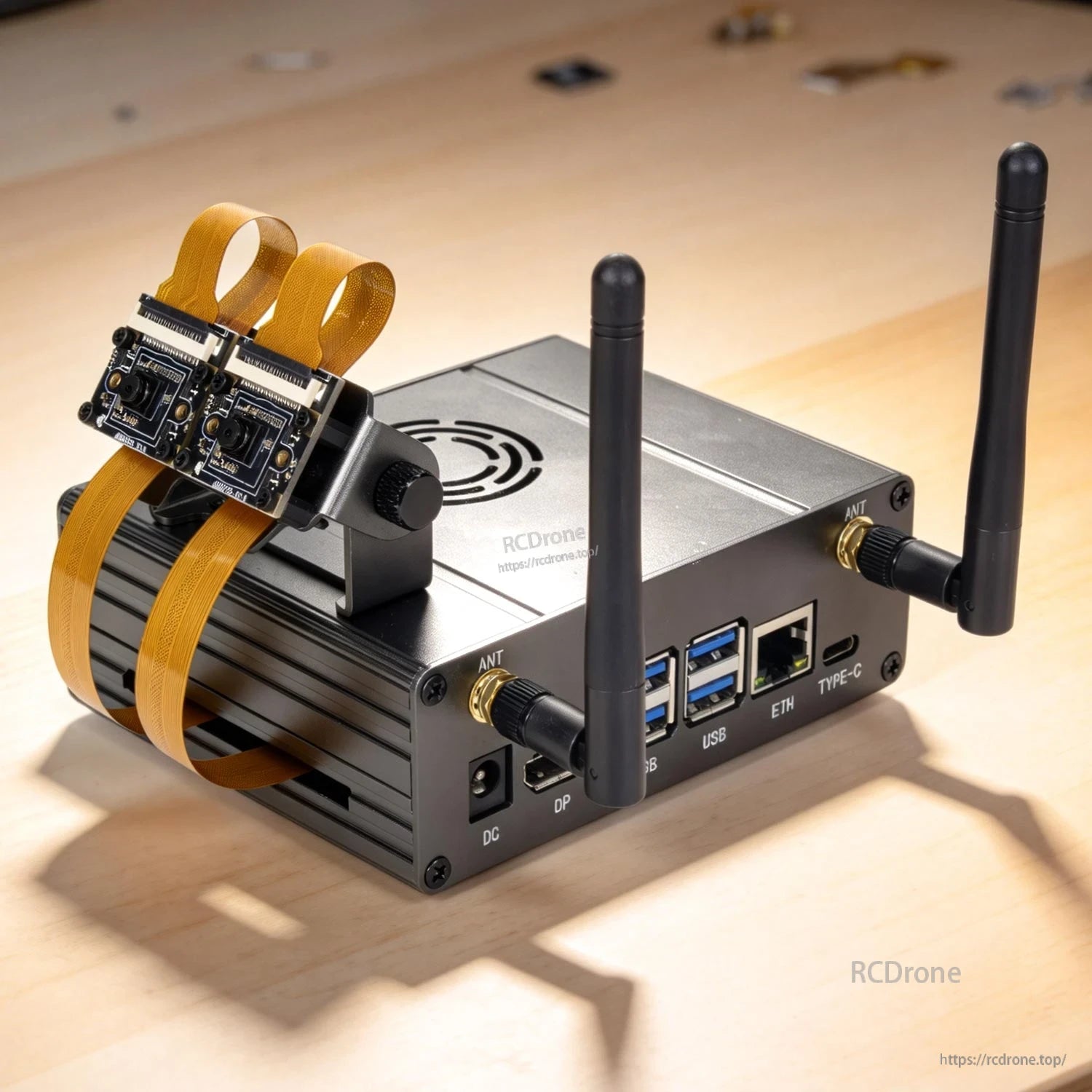 Case on desk setup with dual CSI cameras on bracket, antennas installed, front ports visible
